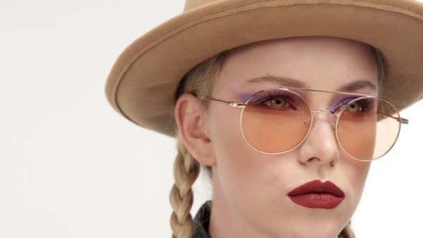 Modellen in muts met twee vlechten en glassess, ziet eruit als een cowboy meisje — Stockvideo