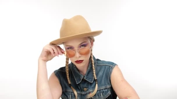 Modeller i hatt med två flätor och glassess, ser ut som en cowboy-flicka — Stockvideo