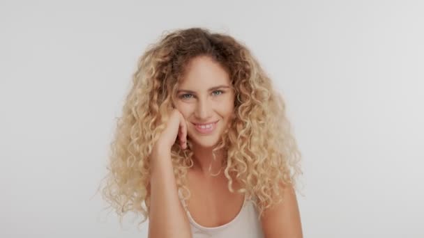 Model in studio met grote blonde krulhaar op wit met natuurlijke make-up — Stockvideo