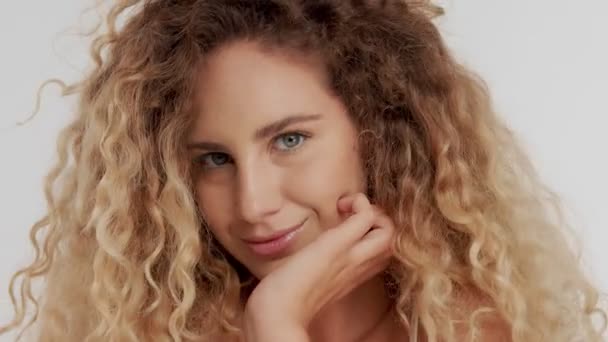 Модель в студии с большими вьющимися светлыми волосами на белом с натуральным макияжем — стоковое видео