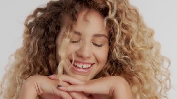 Modell i studio med stora lockigt blont hår på vitt med naturlig makeup — Stockvideo