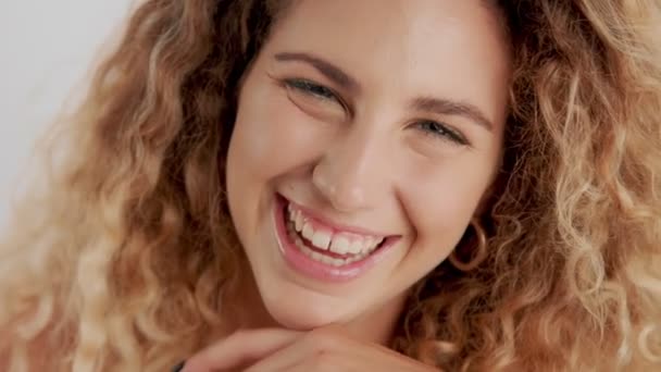 Modelo em estúdio com grande cabelo louro encaracolado em branco com maquiagem natural — Vídeo de Stock