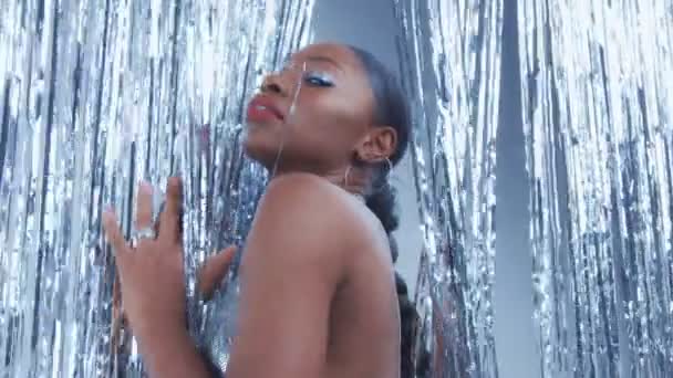 Modelo de raza mixta negra en estilo glamour glow disco sobre fondo de lluvia plateado — Vídeo de stock