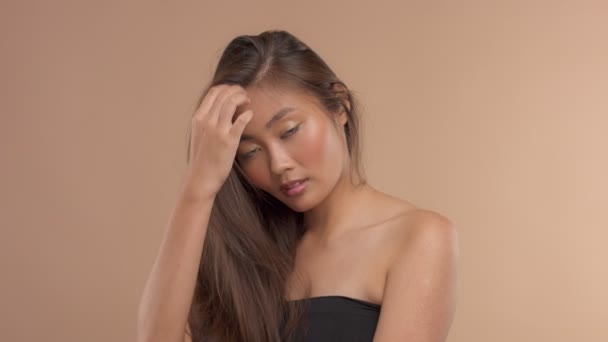 Thailändisches asiatisches Modell mit natürlichem Make-up auf beigem Hintergrund — Stockvideo