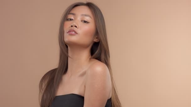 Tajski model Azjatka z naturalnego makijażu na beżowym tle — Wideo stockowe