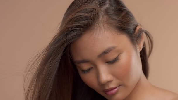 Thai asiatisk modell med naturlig makeup på beige bakgrund — Stockvideo