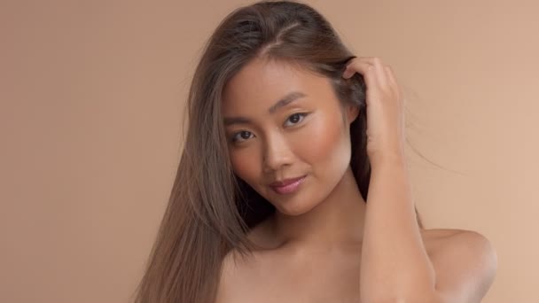 Тайская азиатская модель с натуральным макияжем на бежевом фоне — стоковое видео