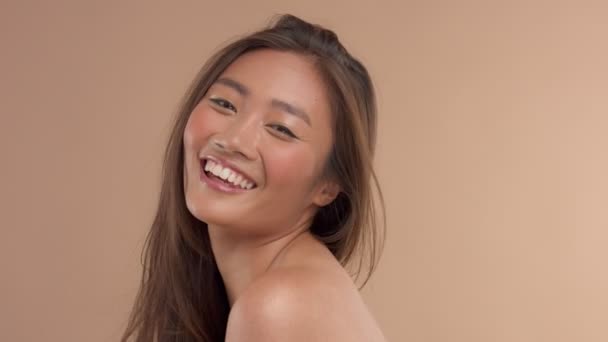 Thailändisches asiatisches Modell mit natürlichem Make-up auf beigem Hintergrund — Stockvideo