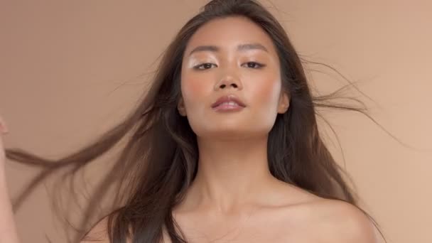 Tailandés asiático modelo con natural maquillaje en beige fondo — Vídeos de Stock