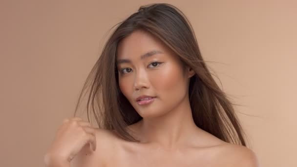 Thai asiatisk modell med naturlig makeup på beige bakgrund — Stockvideo