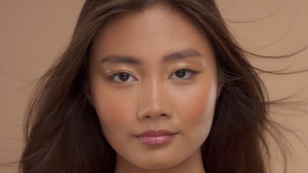 Thai asiatisk modell med naturlig makeup på beige bakgrund — Stockvideo