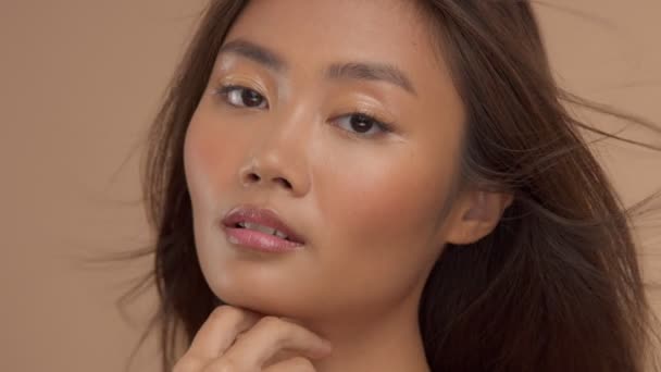 Тайская азиатская модель с натуральным макияжем на бежевом фоне — стоковое видео