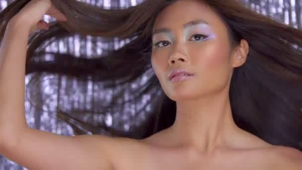 Tailandés asiático modelo en estudio con plata lluvia disco fondo y fiesta maquillaje — Vídeo de stock