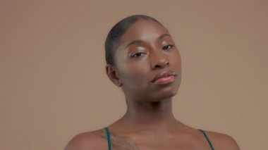 Doğal tarafsız makyaj ile bej renkli arka plan üzerinde siyah karışık ırk modeli