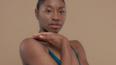 Doğal tarafsız makyaj ile bej renkli arka plan üzerinde siyah karışık ırk modeli