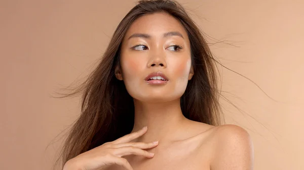 Thailändisches asiatisches Modell mit natürlichem Make-up auf beigem Hintergrund — Stockfoto