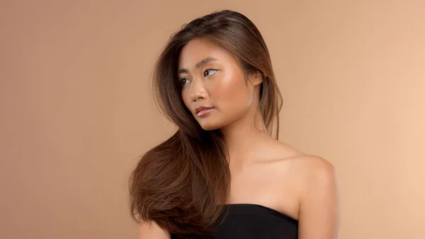 Thailändisches asiatisches Modell mit natürlichem Make-up auf beigem Hintergrund — Stockfoto