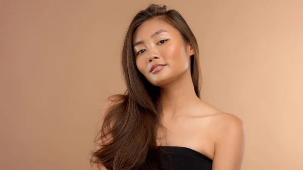 Тайская азиатская модель с натуральным макияжем на бежевом фоне — стоковое фото