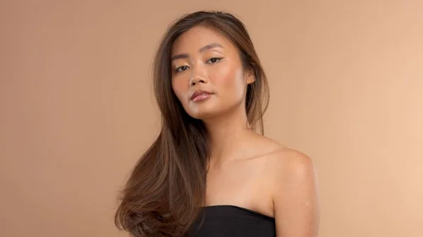 thai asian model with natural makeup on beige background