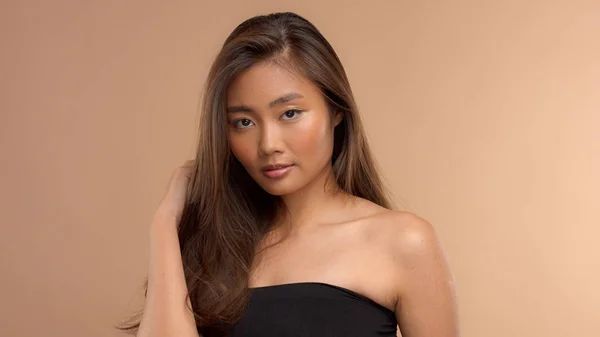 thai asian model with natural makeup on beige background