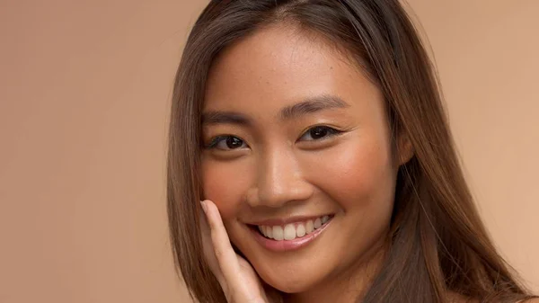 Tajski model Azjatka z naturalnego makijażu na beżowym tle — Zdjęcie stockowe