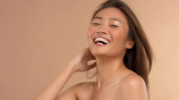 Thailändisches asiatisches Modell mit natürlichem Make-up auf beigem Hintergrund — Stockfoto