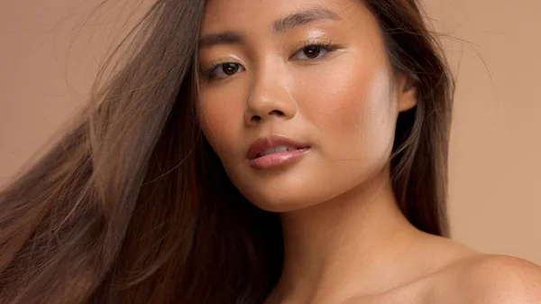 Тайская азиатская модель с натуральным макияжем на бежевом фоне — стоковое фото