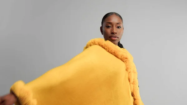 Negro moxed raza mujer en brillante amarillo outwear poncho en gris —  Fotos de Stock