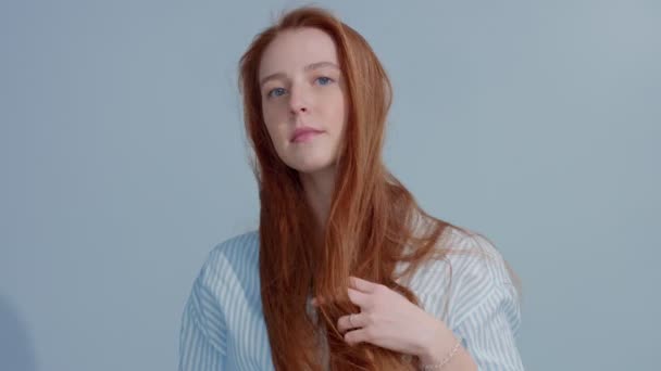 Cabeza de jengibre pelo rojo, modelo de pelo de jengibre con ojos azules sobre fondo azul — Vídeos de Stock