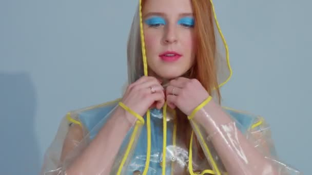 Femme cheveux gingembre en imperméable transparent avec pop art maquillage lumineux danse — Video