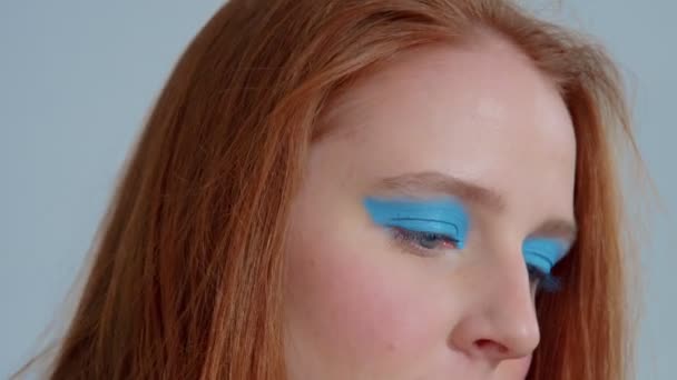 Ingefära hår kvinna i genomskinlig regnrock med popkonst ljus makeup dans — Stockvideo