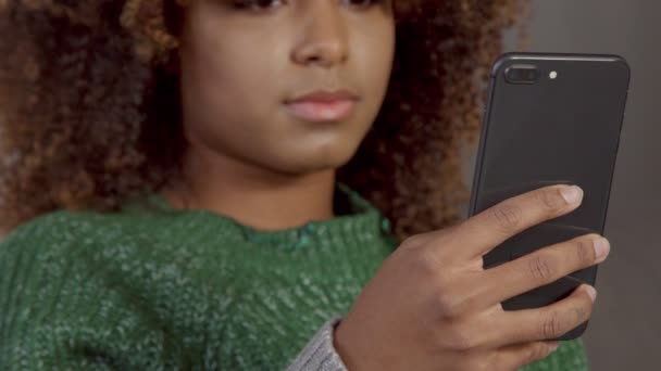 Nahaufnahme einer schwarzen Frau gemischter Rasse mit Mobiltelefon — Stockvideo