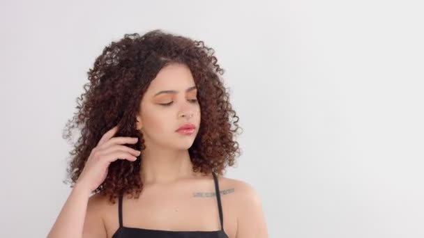 Черная женщина смешанной расы с веснушками и вьющимися волосами в студии на белых позах перед камерой — стоковое видео