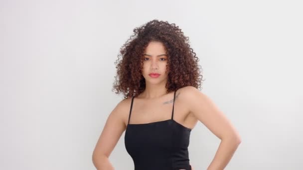 Mixte race femme noire avec des taches de rousseur et les cheveux bouclés en studio sur pose blanche à une caméra — Video