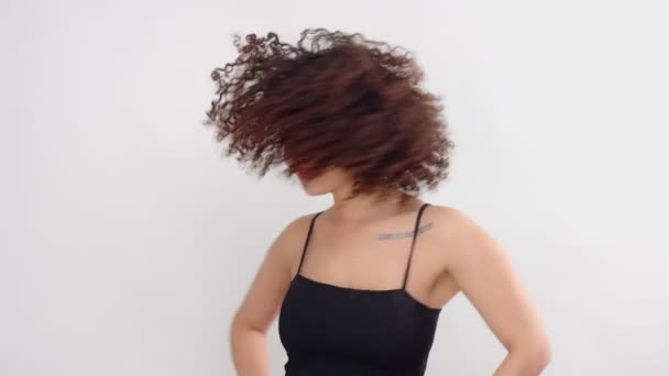 Μικτή φυλή μαύρη γυναίκα με φακίδες και σγουρά μαλλιά στο studio σε λευκό που ενέχει μια φωτογραφική μηχανή — Αρχείο Βίντεο