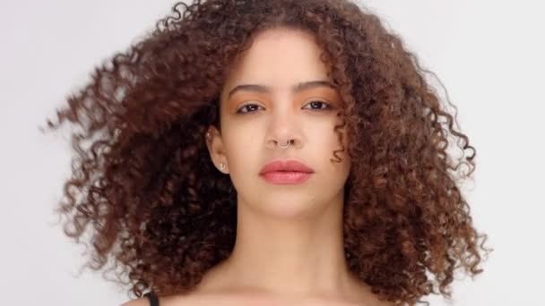 Черная женщина смешанной расы с веснушками и кудрявыми волосами крупным планом портрет с выдуванием волос — стоковое видео