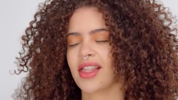 Blandad ras svart kvinna med fräknar och lockigt hår i studio på vita poser till en kamera — Stockvideo