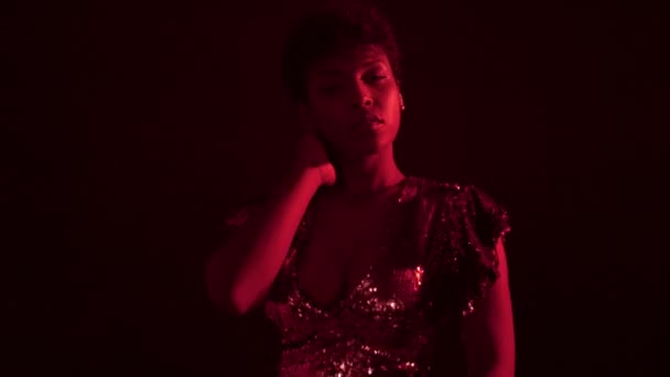 Mujer en vestido brillante en luz roja en discoteca — Vídeo de stock