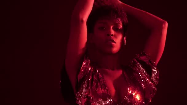 Kvinna i glittrig klänning i rött ljus i nattklubb — Stockvideo