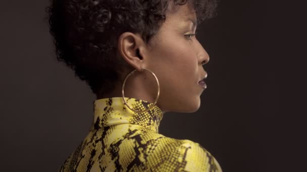 Femme afro-américaine de race mixte en robe jaune vif avec imprimé python. Style années 90 — Video