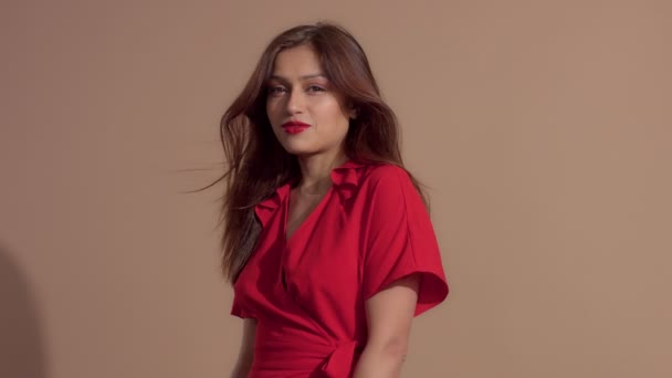 Nő piros ruhában a bézs háttér — Stock videók