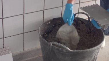 Genç kadın duvara bir Seramik kiremit koymak