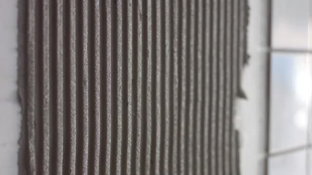 jeune femme a mis un carreau de céramique sur le mur