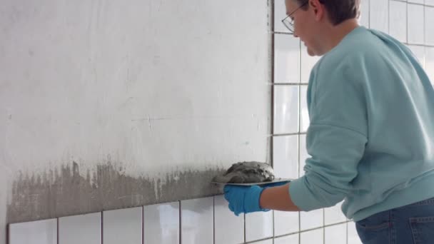 Młoda kobieta umieścić płytki ceramiczne na ścianie — Wideo stockowe