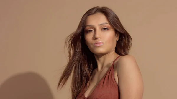 Modelo bastante joven en el estudio sonriendo y mirando a la cámara, cabello que sopla — Foto de Stock