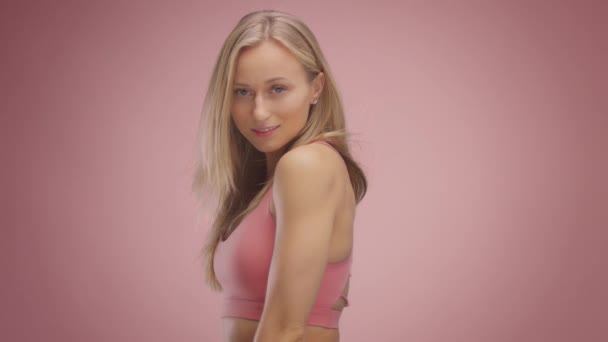 Blond model in studio on pink background with hair blowing in air — Stock Video