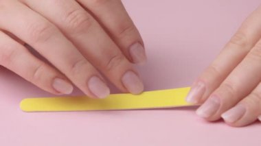 pembe üzerinde closeup kadın el kendisi için manikür yapar