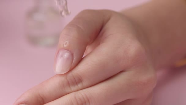 Closeup woman hand on pink makes manicure for herself — Stock Video