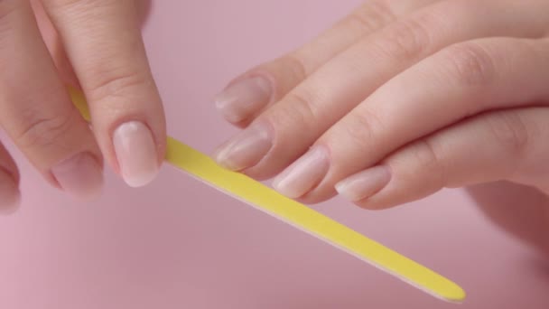 Primer plano mujer mano en rosa hace manicura para sí misma — Vídeos de Stock