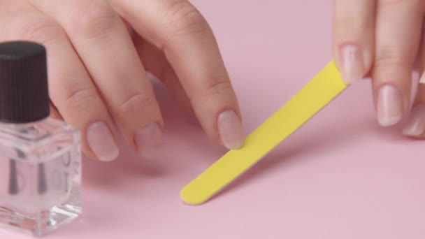 Close-up vrouw hand op roze maakt manicure voor zichzelf — Stockvideo